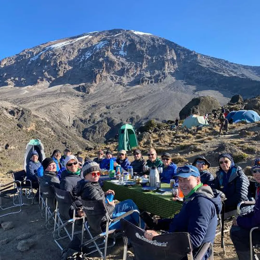 Best KPAP certified Kilimanjaro tour operators and guide checking porter gear on mountain path