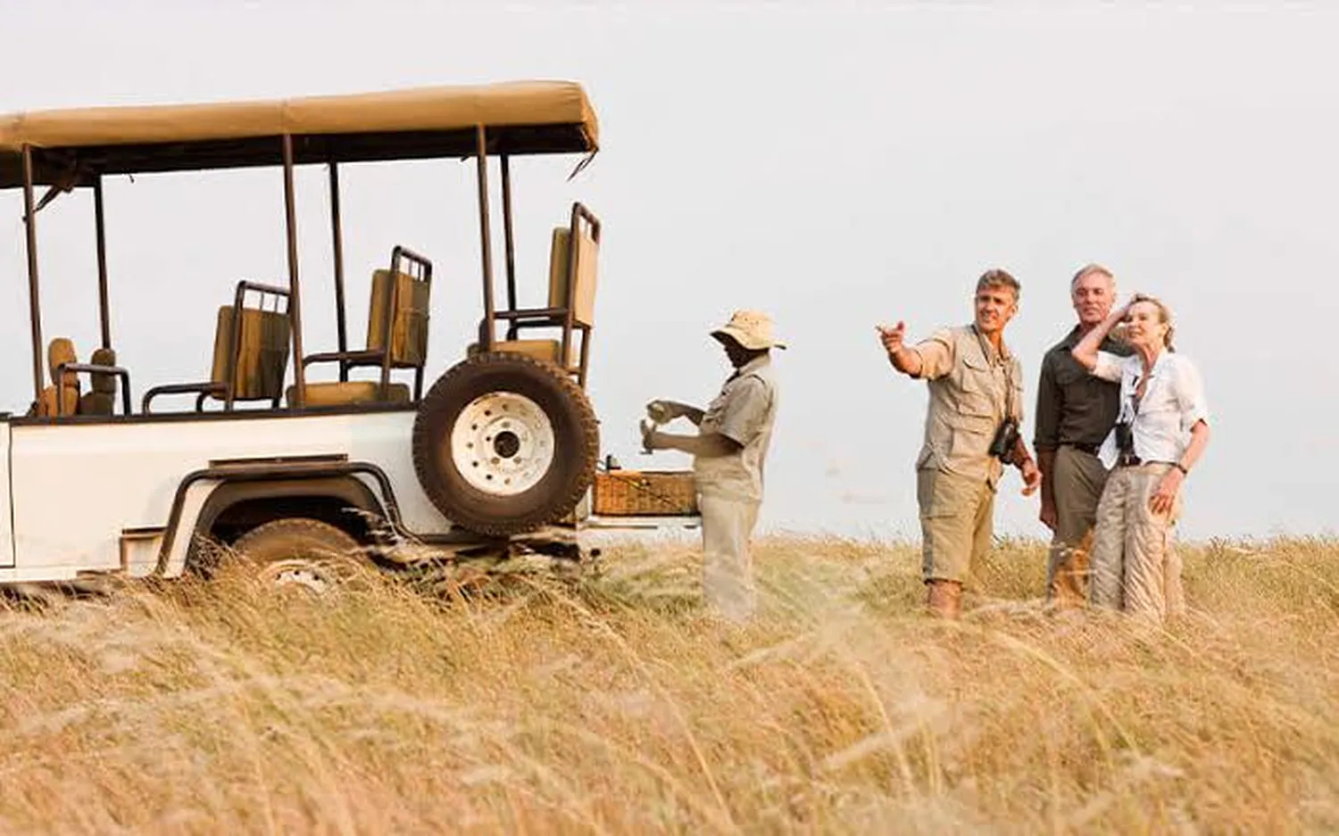 How to pack for a luxury safari in East Africa - high-end duffel bags, neutral clothes, and binoculars arranged for travel
