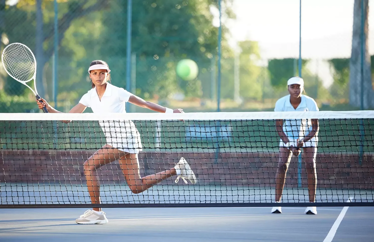 Professional tennis player performing a powerful forehand on a blue hard court