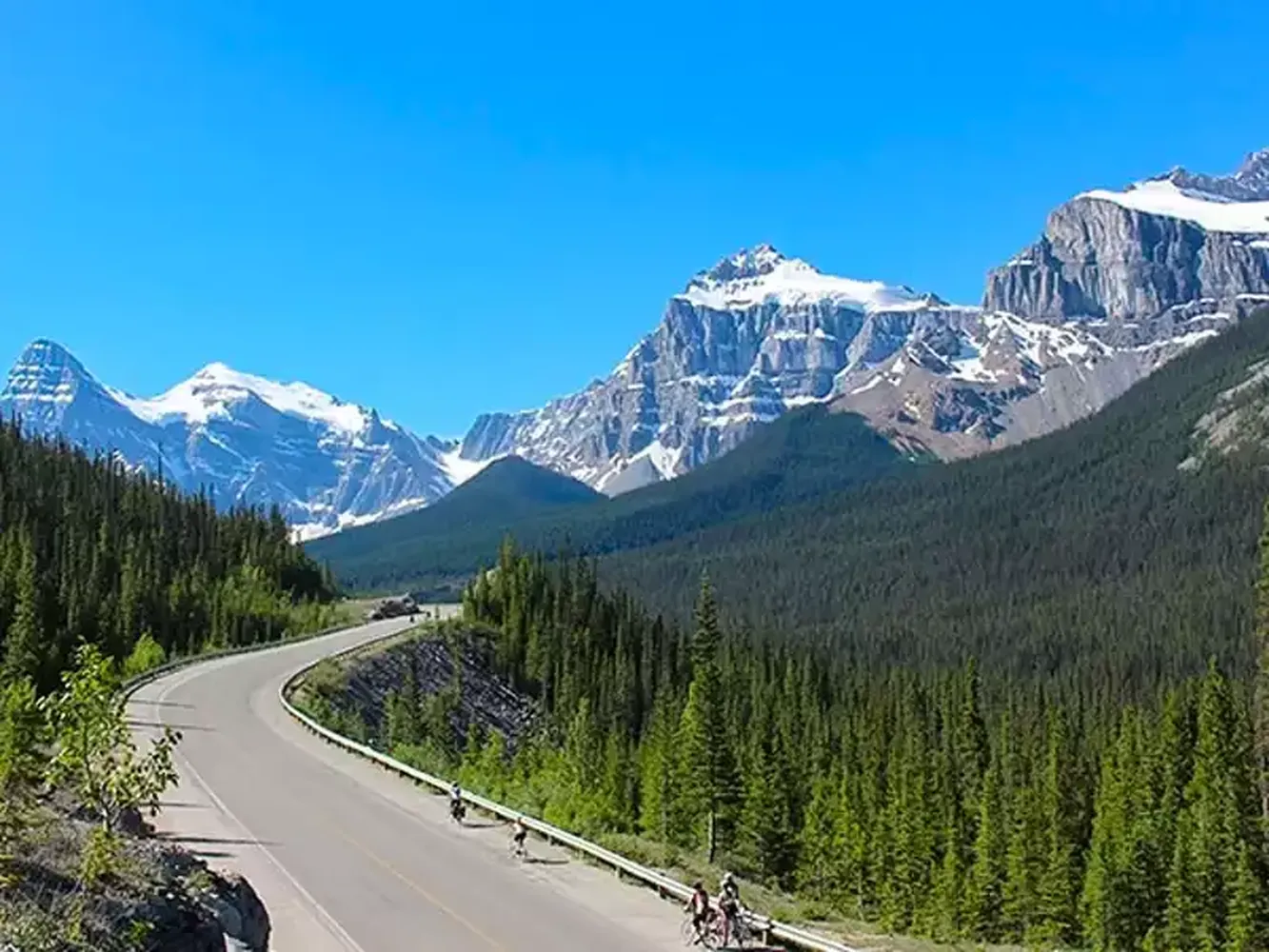 How to take scenic drives in the Canadian Rockies - breathtaking mountain road with turquoise lake and pine trees