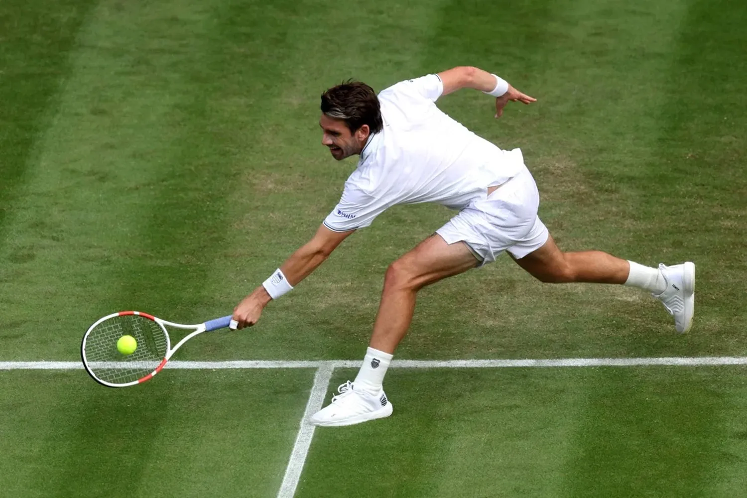 Beginner tennis player practicing footwork drills with agility cones on court